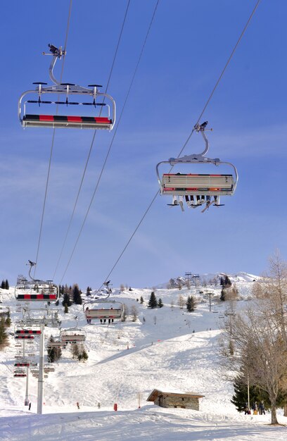 Sessellift unter blauem Himmel und über Skipiste