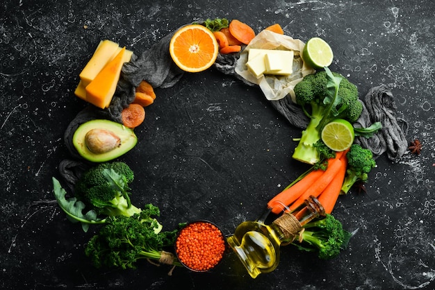 Set aus Gemüse, Obst und Lebensmitteln auf schwarzem Steinhintergrund Lebensmittel sind reich an Vitamin A Draufsicht Freier Platz für Ihren Text