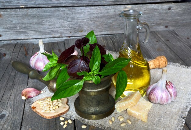 Set aus Kräutern, Gewürzen und anderen Produkten für die Zubereitung von italienischer Pesto-Sauce auf dunklem Holzhintergrund