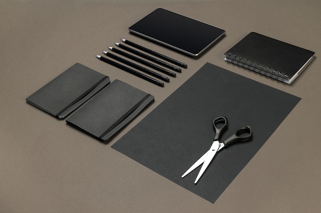 Set aus schwarzem Büromaterial auf grauem Hintergrund flach
