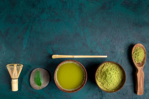 Set para cocinar té verde matcha sobre fondo esmeralda. Vista superior.