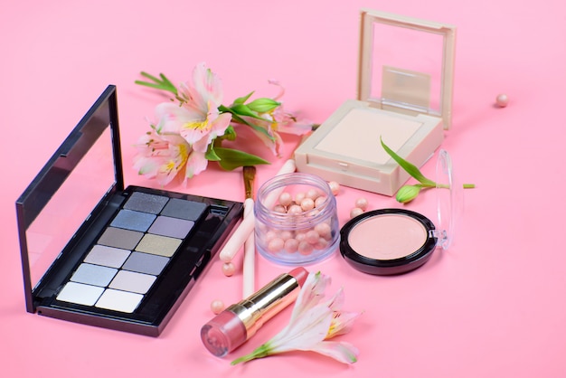 Set de cosmética decorativa con pinceles de maquillaje sobre fondo rosa