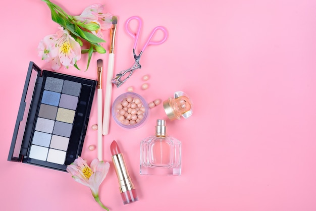 Set de cosmética decorativa con pinceles de maquillaje sobre fondo rosa