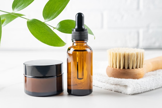 Set de cuidado de la piel con crema facial de aceite de belleza y cepillo de madera con cerdas naturales para masaje dy Concepto de tratamiento orgánico de belleza