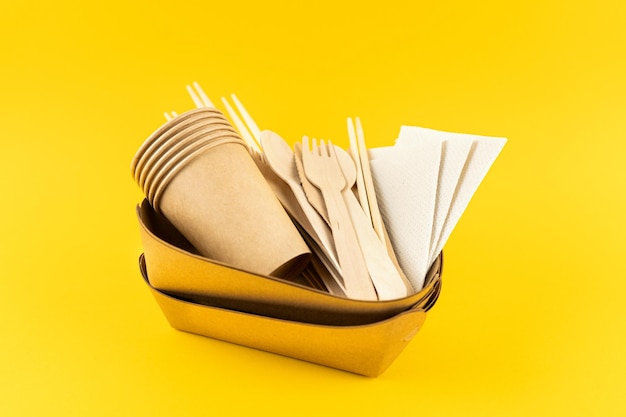 Set Öko-Geschirr auf gelbem Hintergrund Craft Teller Kaffeetassen Bambus Utensilien Seitenansicht