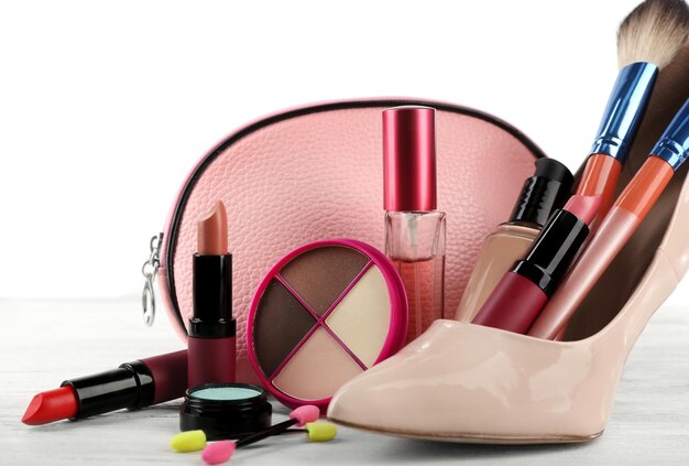 Set de maquillaje con cepillos de zapatos de mujer beige esteticista y cosméticos sobre fondo claro