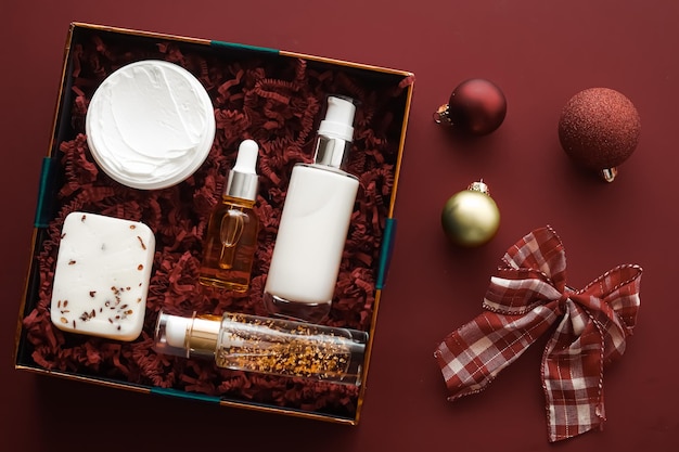 Set de regalo de navidad paquete de suscripción de caja de belleza de vacaciones de navidad y productos de lujo para el cuidado de la piel plano cosmético plano sobre fondo de chocolate cosméticos como regalo de vacaciones o entrega de compras