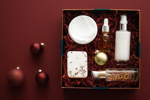 Set de regalo de navidad paquete de suscripción de caja de belleza de vacaciones de navidad y productos de lujo para el cuidado de la piel plano cosmético plano sobre fondo de chocolate cosméticos como regalo de vacaciones o entrega de compras