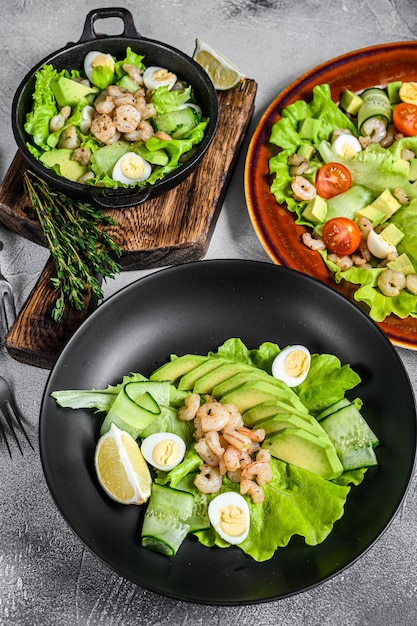 Set Salate mit Avocado, Garnelen, Garnelen und Gemüse in Schalen