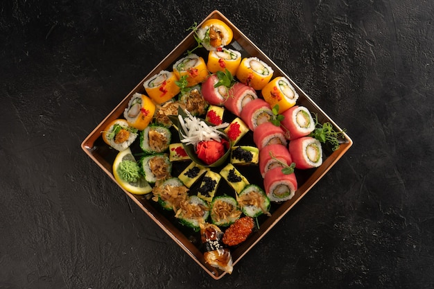 Set de sushi con diferentes tipos de rollitos y sashimi a base de anguila, salmón, atún, camarón, caviar rojo y huevas de pez volador tobiko.