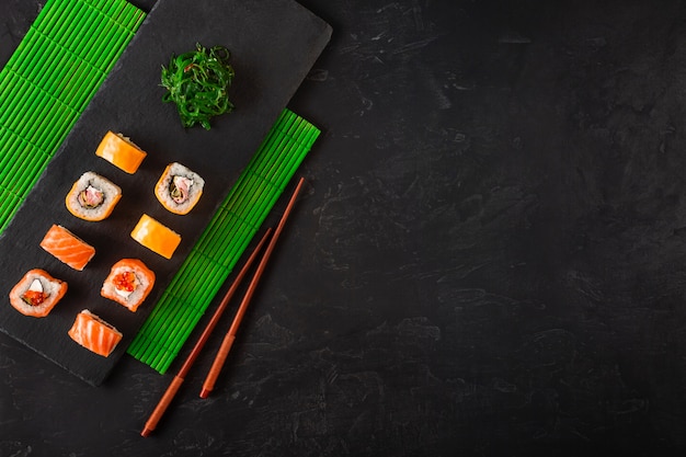 Foto set de sushi y maki en mesa de piedra.