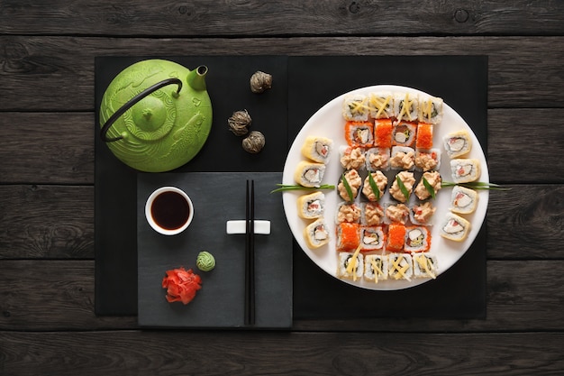 Set de sushi maki y rollos en madera rústica negra