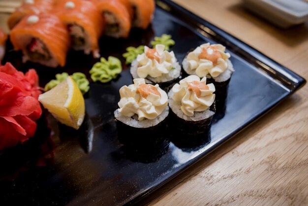 Set de sushi Rollos de salmón, anguila y caviar rojo en un plato de madera. Restaurante.