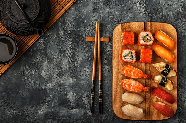 Set de sushi: sushi y rollos de sushi en placa de madera.