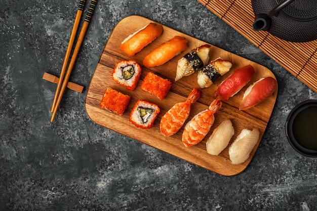 Set de sushi: sushi y rollos de sushi en placa de madera.