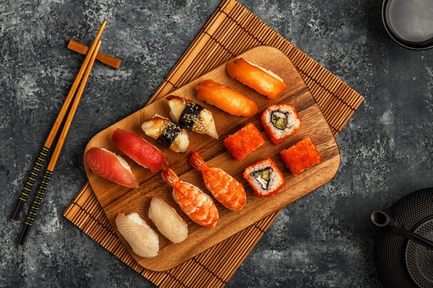 Set de sushi: sushi y rollos de sushi en placa de madera.