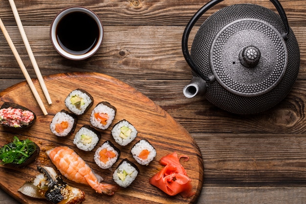 Set de sushi, té y salsa de soja sobre fondo de madera.