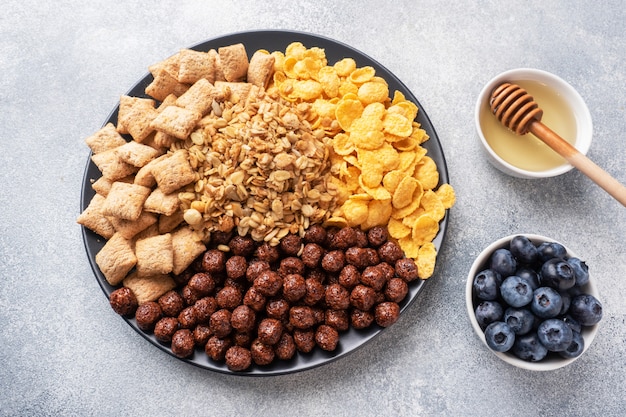 Set trockene Müsliflocken zum Frühstück mit Milch und Beeren.