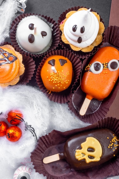 Set von Halloween-Süßigkeiten auf schwarzem und braunem Hintergrund