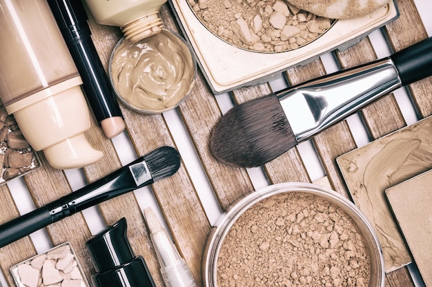 Set von Make-up-Produkten mit Make-up-Pinsel auf Holzständer