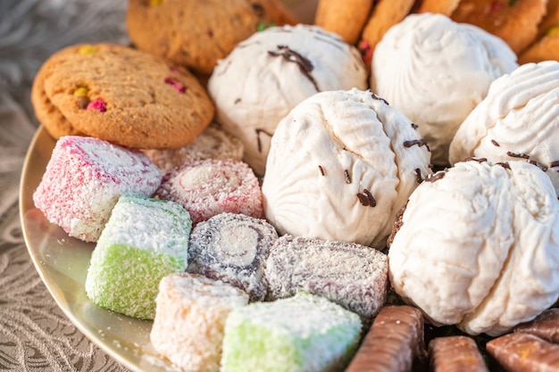 Set von Süßwaren. Süßigkeiten auf dem Teller - Zephyr, Marmelade, Kekse und Schokoladenstäbchen. Nahaufnahme stockfoto