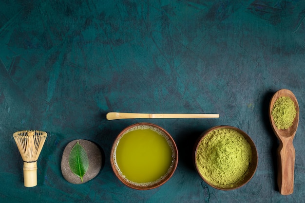 Set zum Kochen von grünem Matcha-Tee auf smaragdgrüner Kulisse. Draufsicht.