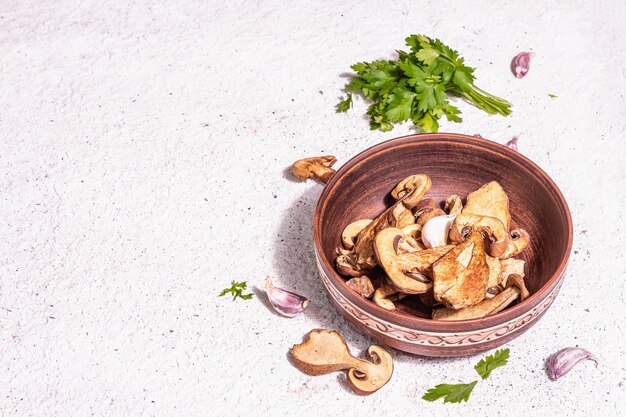 Setas secas Boletus edulis (Penny bun, Cep, Porcini) sobre fondo de yeso con textura. Ingrediente para comida sana vegetariana (vegana). Una luz dura de moda, sombra oscura, espacio de copia