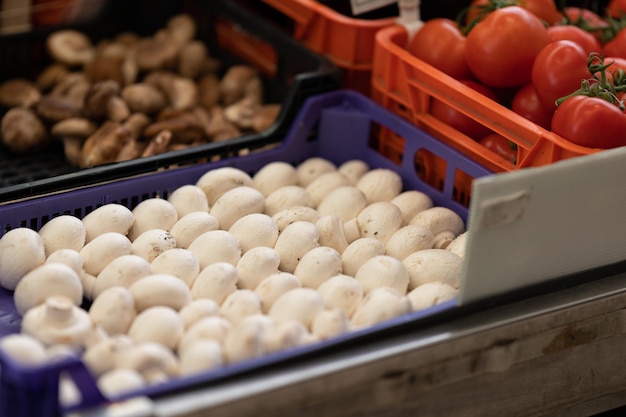 Setas y tomates en envases de plástico en el mercado