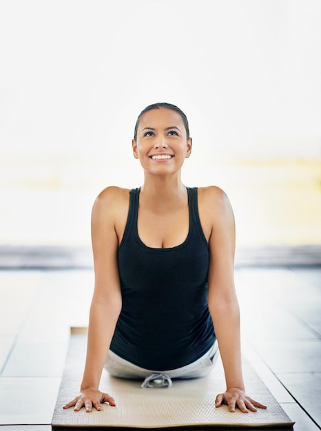 Foto setzen sie diese endorphine frei aufnahme einer jungen frau, die zu hause yoga macht