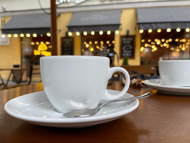 Setzen Sie eine Kaffeetasse auf den Tisch im Café im Freien?