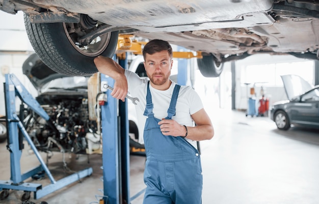 Seu carro está em boas mãos. Funcionário com uniforme azul trabalha no salão automóvel