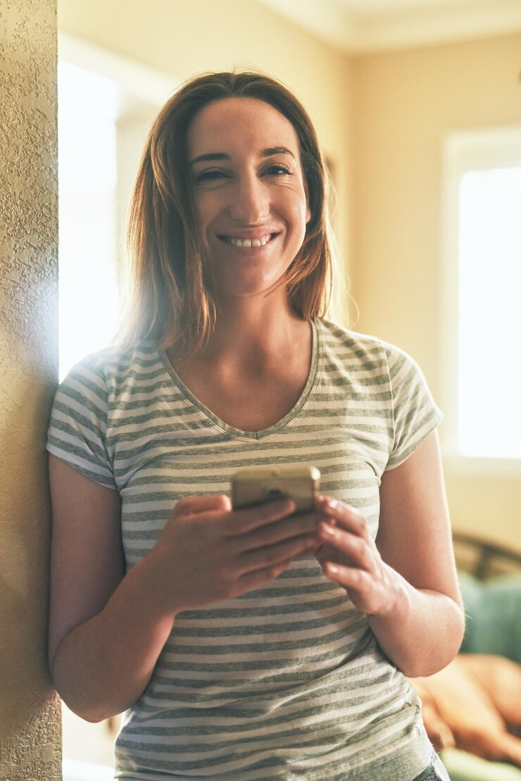 Foto seu fim de semana em casa, mas ela estará ocupada fazendo networking retrato de uma jovem usando um celular pela manhã em casa
