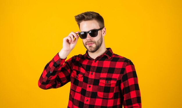 Seus projetos estão em demanda retrato interno do empresário europeu sexy confiante e calmo homem casual bonito de pé com barba e cerdas homem bonito alegre e elegante em óculos de sol