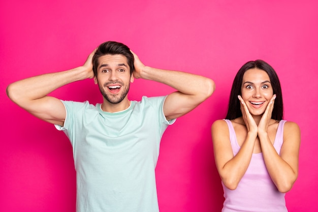 Sexta-feira negra louca! Foto de um casal incrível olhando para os preços baixos das compras e vestindo roupas casuais elegantes isoladas de fundo rosa vibrante