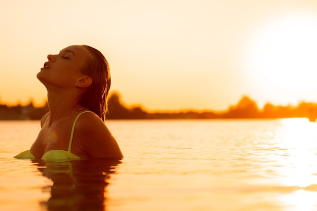 Foto sexuelle junge dame im meer bei warmem sonnenuntergang