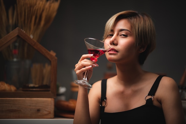 Sexy asiatisches Mädchen, das Rotweingläser hält