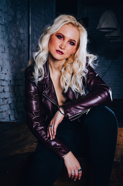 Sexy blondes Mädchen in der purpurroten Lederjacke