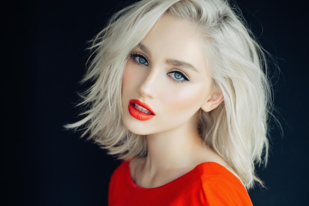 Sexy Blondine des Porträts im Studioschwarzhintergrund