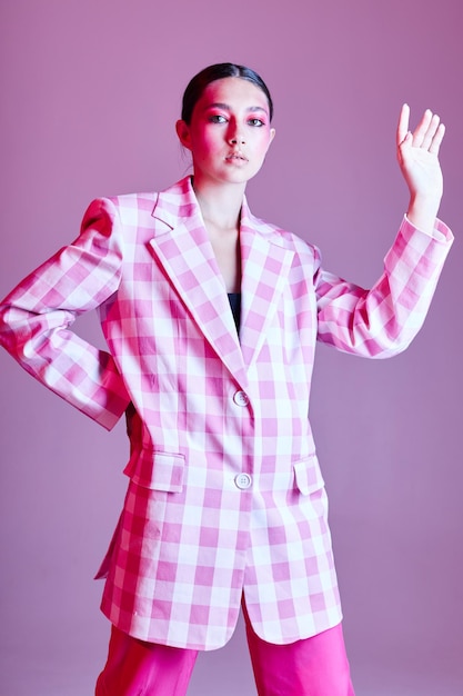 Sexy Brünette Frau Luxuskleidung Mode Plaid Blazer rosa Hintergrund unverändert