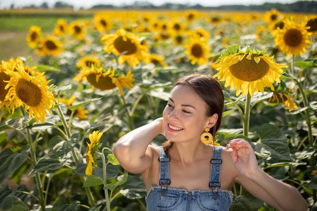 Sexy chica ucraniana en un campo con girasoles en un día soleado