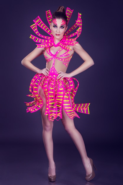 Sexy Disco-Tänzerin posiert im UV-Kostüm