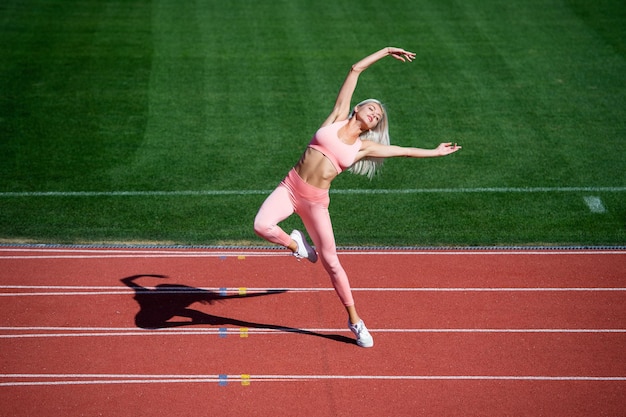 sexy Fitness-Frau, die sich in Sportbekleidung im Stadion ausdehnt, Flexibilität.