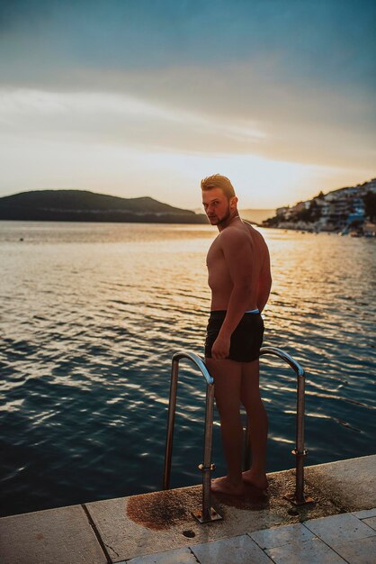 Foto sexy fitter mann posiert am strand