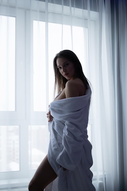 Sexy Frau, die Brust im Schlafzimmer bedeckt