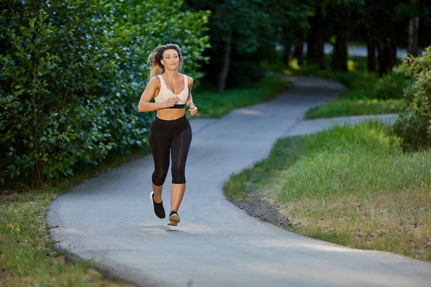 Sexy Frau macht abends im Sommerpark joggen