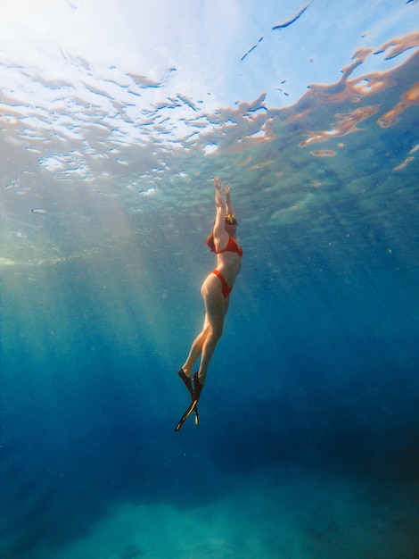 Sexy Frau schwimmt unter Wasser in Tauchmaske mit Schwimmflossen Sommerurlaub