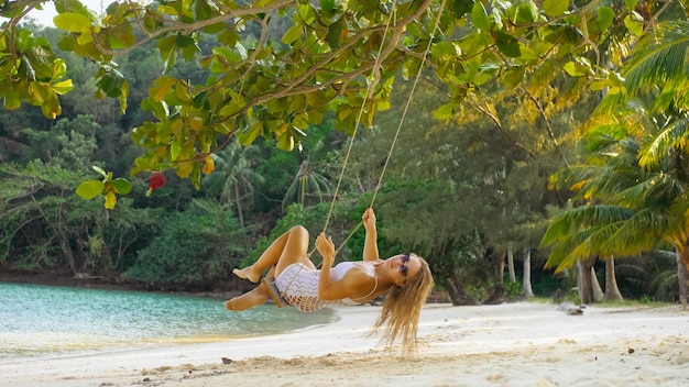 Sexy heiße Frau schwingt auf einer Schaukel Erotic Bad Girl posiert am Strand vor dem Hintergrund des Meeres Konzept natürliche Schönheit Körper Weiblichkeit und Sexualität Ausschweifung und Mut