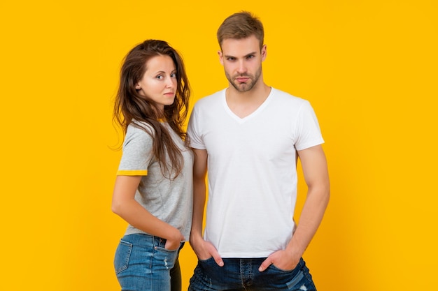 Sexy hombre y mujer de pie juntos en camisa a cuadros en relación de fondo amarillo