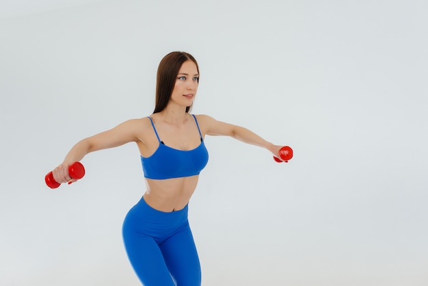 Sexy joven saltando la cuerda en un chándal azul. Fitness, estilo de vida saludable.