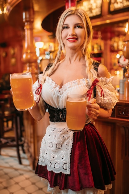 Foto sexy kellnerin in retro-uniform hält tassen bier